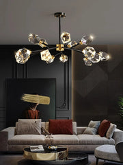 Modern chandelier hanging above a living room with a sofa and decorative pillows.