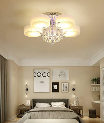A bedroom with a bed and nightstands, featuring a crystal ceiling light fixture.