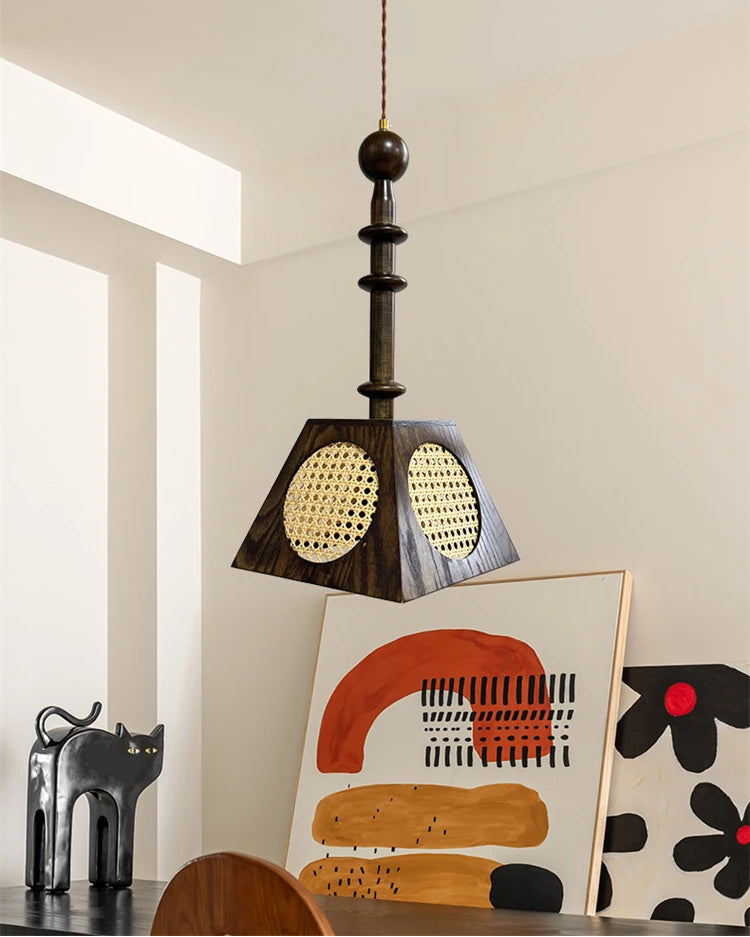 Pendant light fixture hanging in a room with abstract art and decor.
