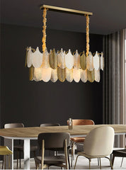 Modern chandelier hanging above a dining table with chairs in a room.