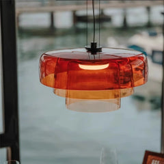 Orange pendant light with a blurred waterfront background