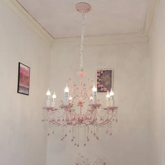 The pink floral crystal chandelier hanging from a ceiling in a room, with wall art visible in the background.