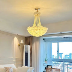 Chandelier hanging in a living room with a cityscape view through a window.