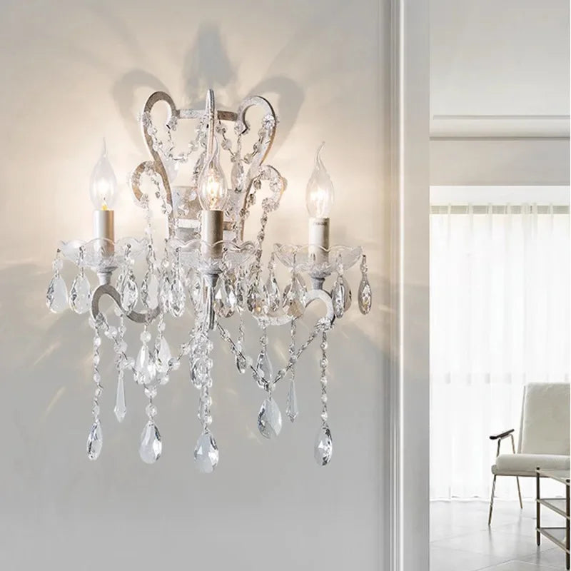 Crystal wall sconce on a white wall with a blurred room background