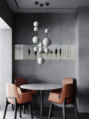 Modern dining area with a round table and chairs against a gray wall with a mirror.