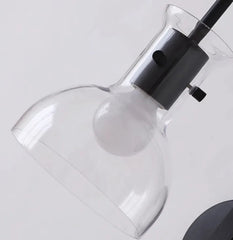 Modern light fixture with clear glass shade and black base on a white background