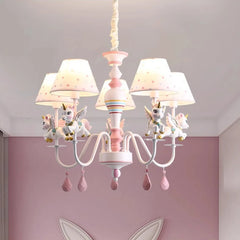 Unicorn chandelier in a pink-themed child's bedroom, providing soft illumination.