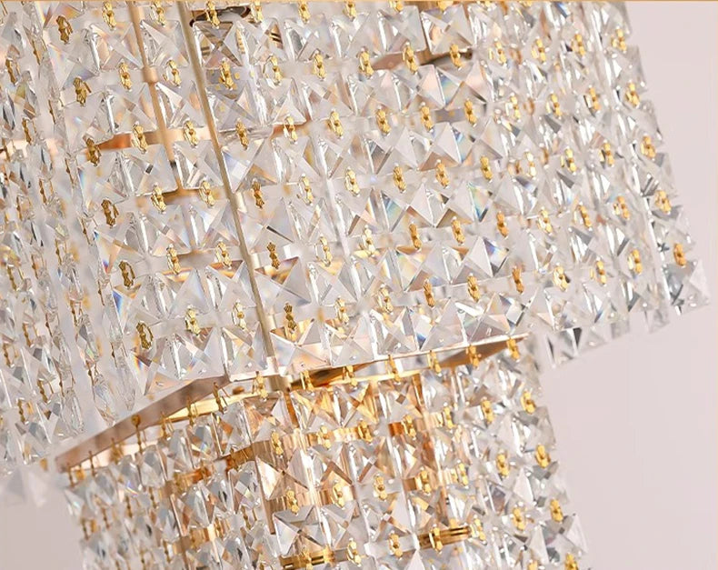 Close-up of a crystal chandelier with gold accents on a light background
