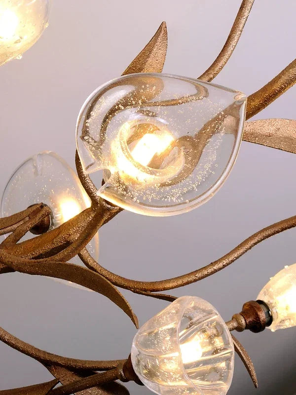 Close-up of a chandelier with leaf-shaped glass shades on a gray background