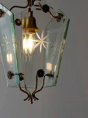 Vintage-style chandelier with brass fixtures and glass shades on a plain background