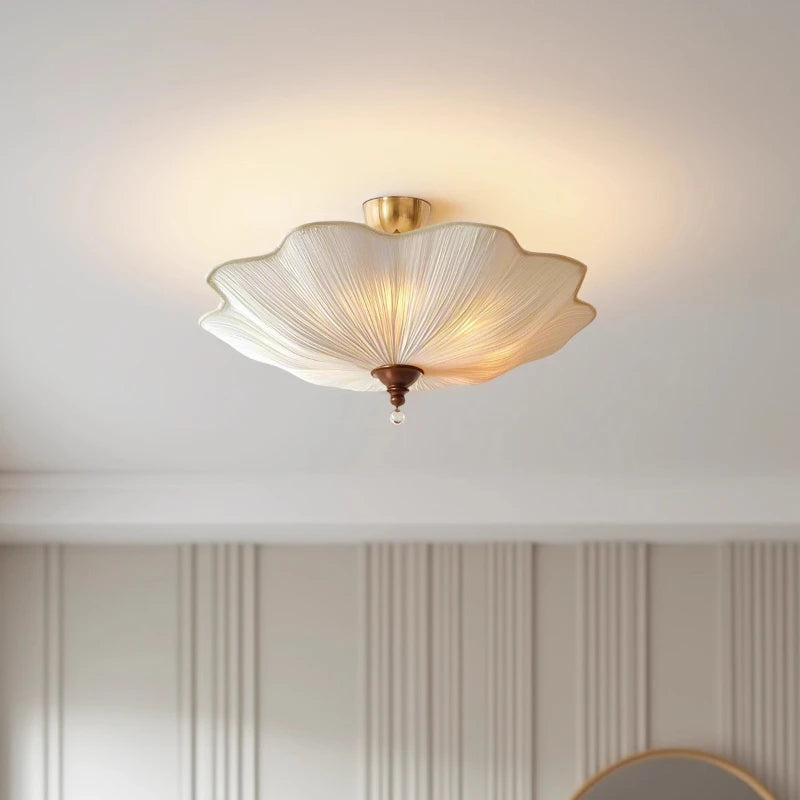Interior view of a room featuring a white fabric lotus-shaped semi-flush ceiling light, casting a warm glow.