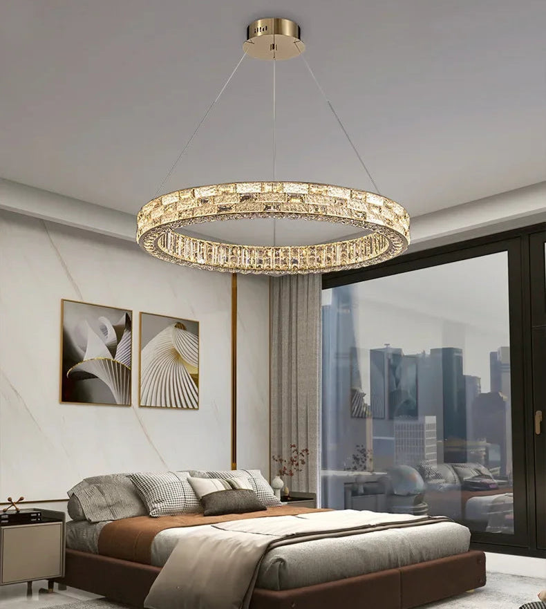 Modern chandelier hanging above a bed in a stylish bedroom with cityscape view.