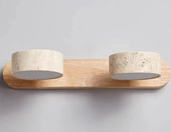 Wall-mounted light fixture with wooden base and stone-like lampshades on a gray background