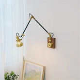 Brass adjustable swing arm wall sconce mounted on a white wall with a wooden base and knob switch.