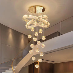 Modern chandelier hanging in a staircase area with a neutral color scheme.