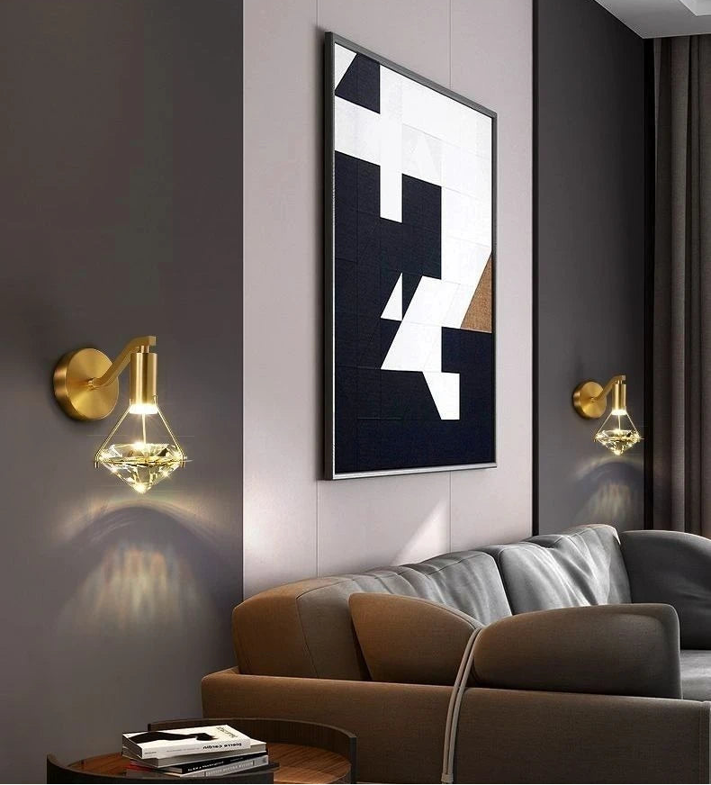 Modern living room with abstract art, gold wall sconces, and a brown sofa.