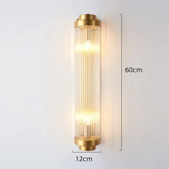 Gold wall sconce with clear glass shade on a white background, showing dimensions.