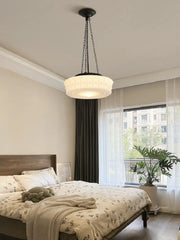 Modern bedroom with a chandelier, bed, and large window.