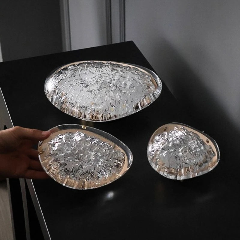 Three round glass trays with textured surfaces on a dark surface.