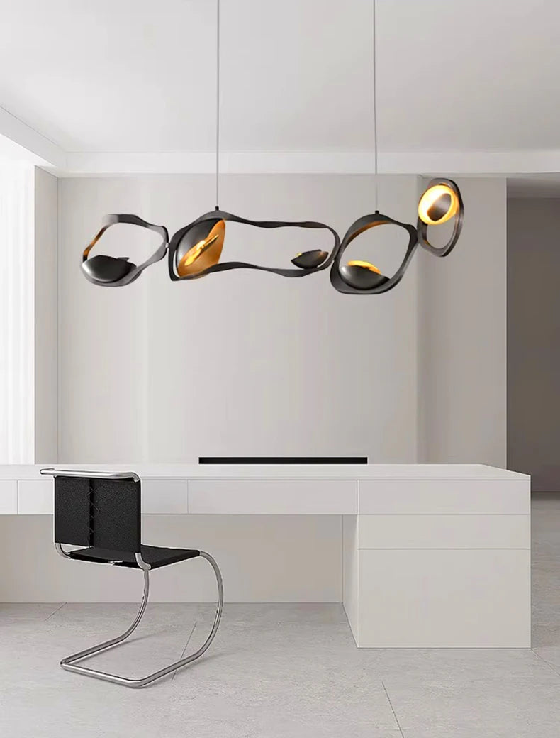 Modern office setup with a white desk, black chair, and stylish pendant lights.