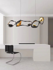 Modern office setup with a white desk, black chair, and stylish pendant lights.