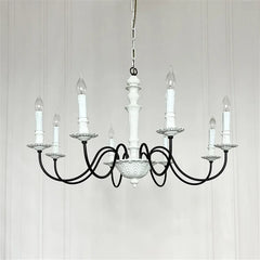Black chandelier with white candles on a light gray background