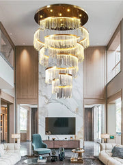 Luxurious chandelier hanging in a modern living room with marble walls and high ceilings.