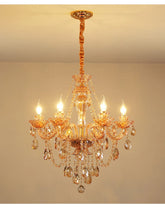 Gold crystal chandelier with cascading teardrop and faceted crystal accents, featuring candle-style bulbs and a polished gold finish.