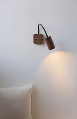 Wooden wall sconce on a white wall with a soft glow