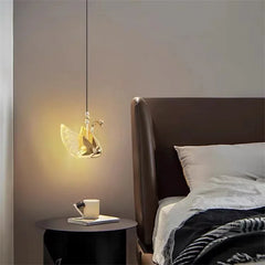 Modern bedroom with a swan-shaped pendant light and a bed.