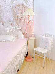Pastel-colored bedroom with a bed, chair, and lamp.