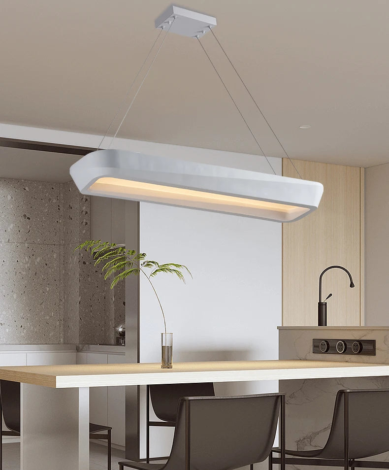 Modern pendant light hanging above a kitchen counter with a neutral color scheme.