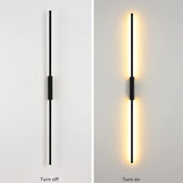Black linear wall sconce in a turned-off state against a white wall.
