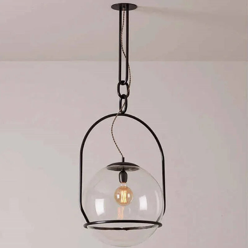 Pendant light with clear glass shade and visible bulb against a plain background