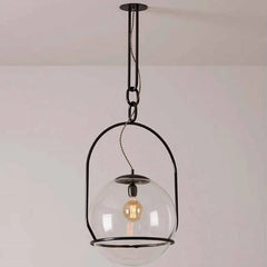 Pendant light with clear glass shade and visible bulb against a plain background
