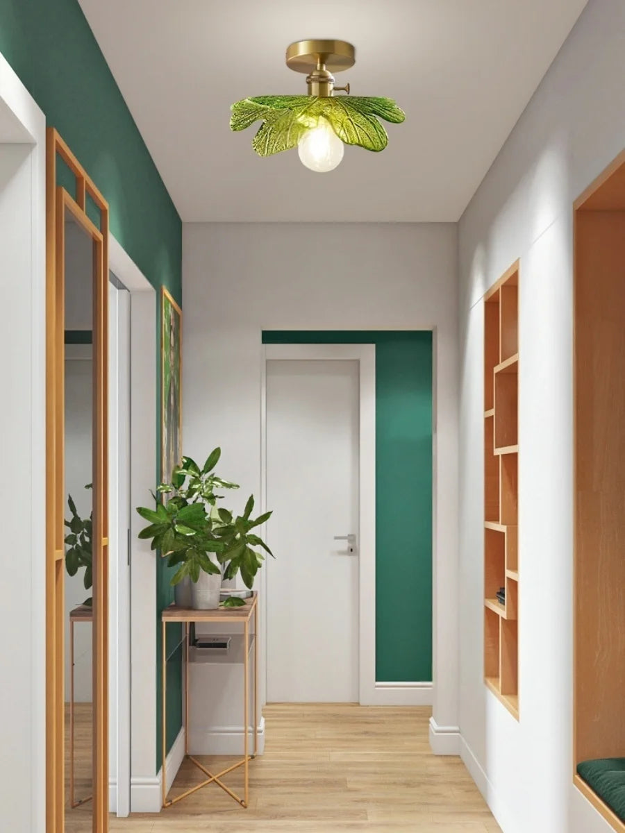 Modern interior hallway with green wall, ceiling light fixture, and wooden furniture.