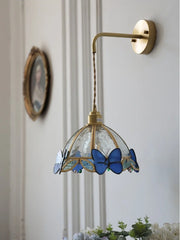 Wall-mounted lamp with butterfly design on a light-colored wall.