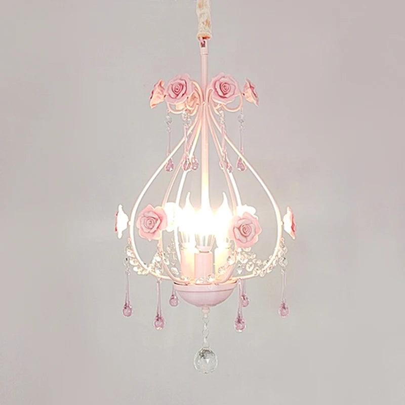 Close-up of a pink floral crystal pendant light with rose accents and cascading droplets.