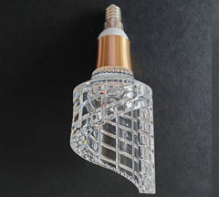 Decorative light bulb with crystal design on a dark background