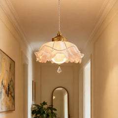A gold floral pendant light with crystal accents hanging in a hallway.