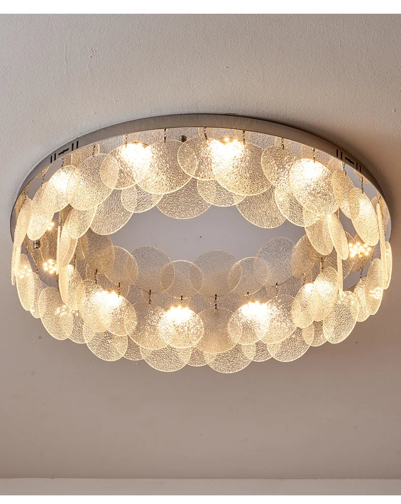 Close-up view of a round ceiling light with a chrome frame and a dense arrangement of clear, textured glass circles
