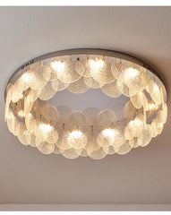 Close-up view of a round ceiling light with a chrome frame and a dense arrangement of clear, textured glass circles
