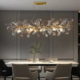 Gold leaf crystal chandelier with a branch-like design hanging over a dining table.