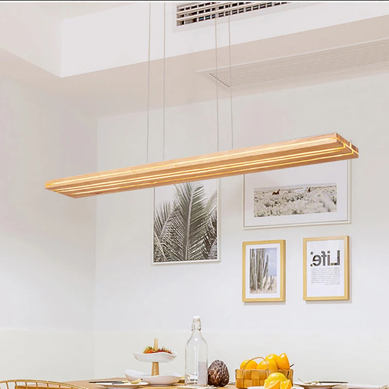 Modern pendant light fixture in a kitchen setting with framed pictures on the wall.
