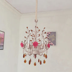 Side view of a pink and gold semi-flush mount chandelier adorned with ceramic roses and amber crystals, mounted on a textured ceiling.