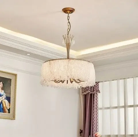 Side view of the gold crystal waterfall pendant light against a white ceiling and wall.