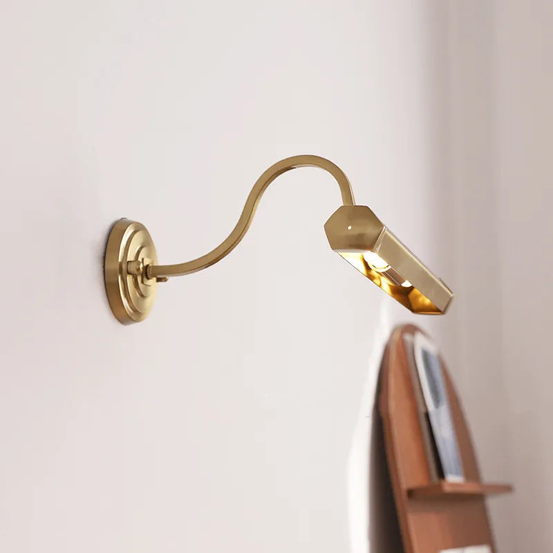 Side view of a brushed brass wall sconce, highlighting the angled light head and its warm illumination.