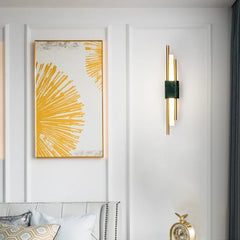 Decorative wall art with abstract design on a white wall, accompanied by a gold wall sconce.
