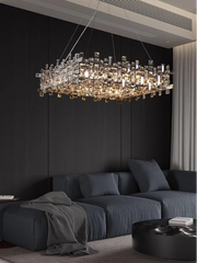 Modern chandelier hanging above a dark sofa in a living room.