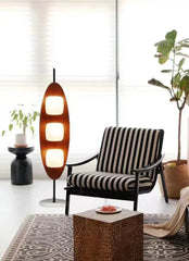 Modern living room with a striped armchair, floor lamp, and decorative items.